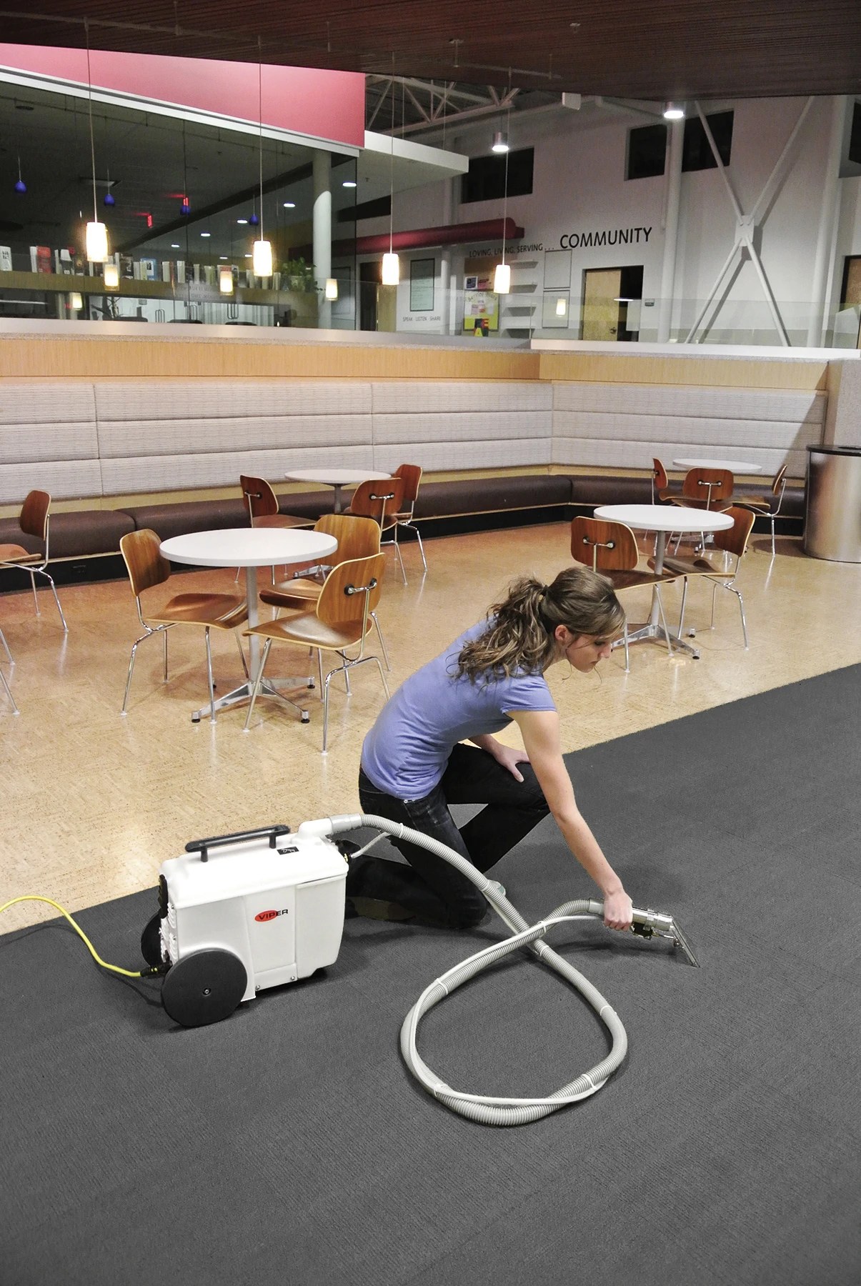 Cleaner using the Viper Wolf130 carpet spotter and hand tool on carpet in a building lobby