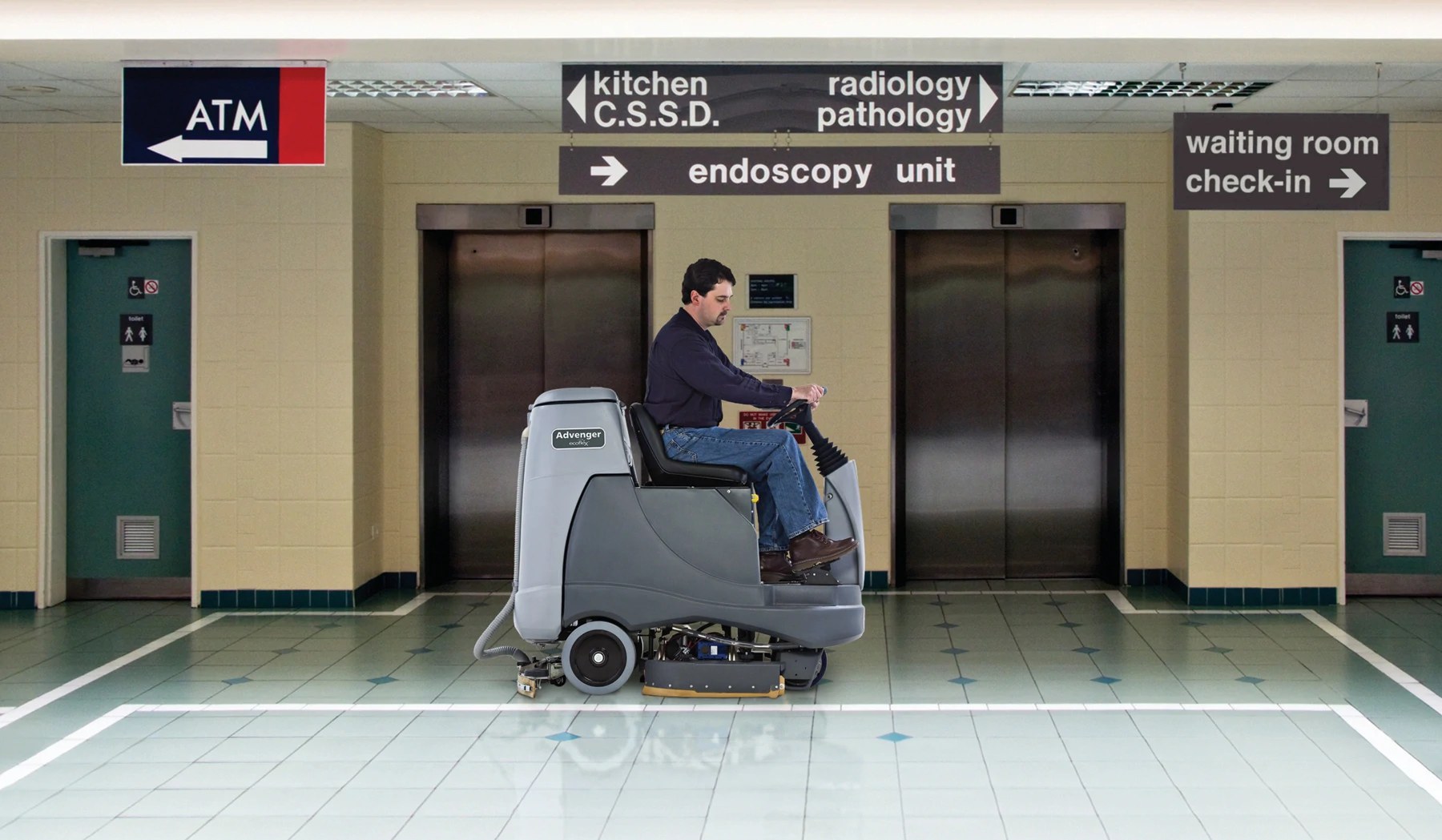 Operator riding an Advance Advenger disc scrubber through a hospital elevator lobby