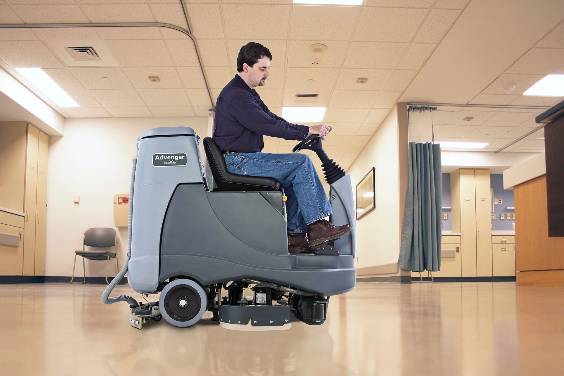 Operator riding an Advance Advenger REV scrubber down a hospital corridor