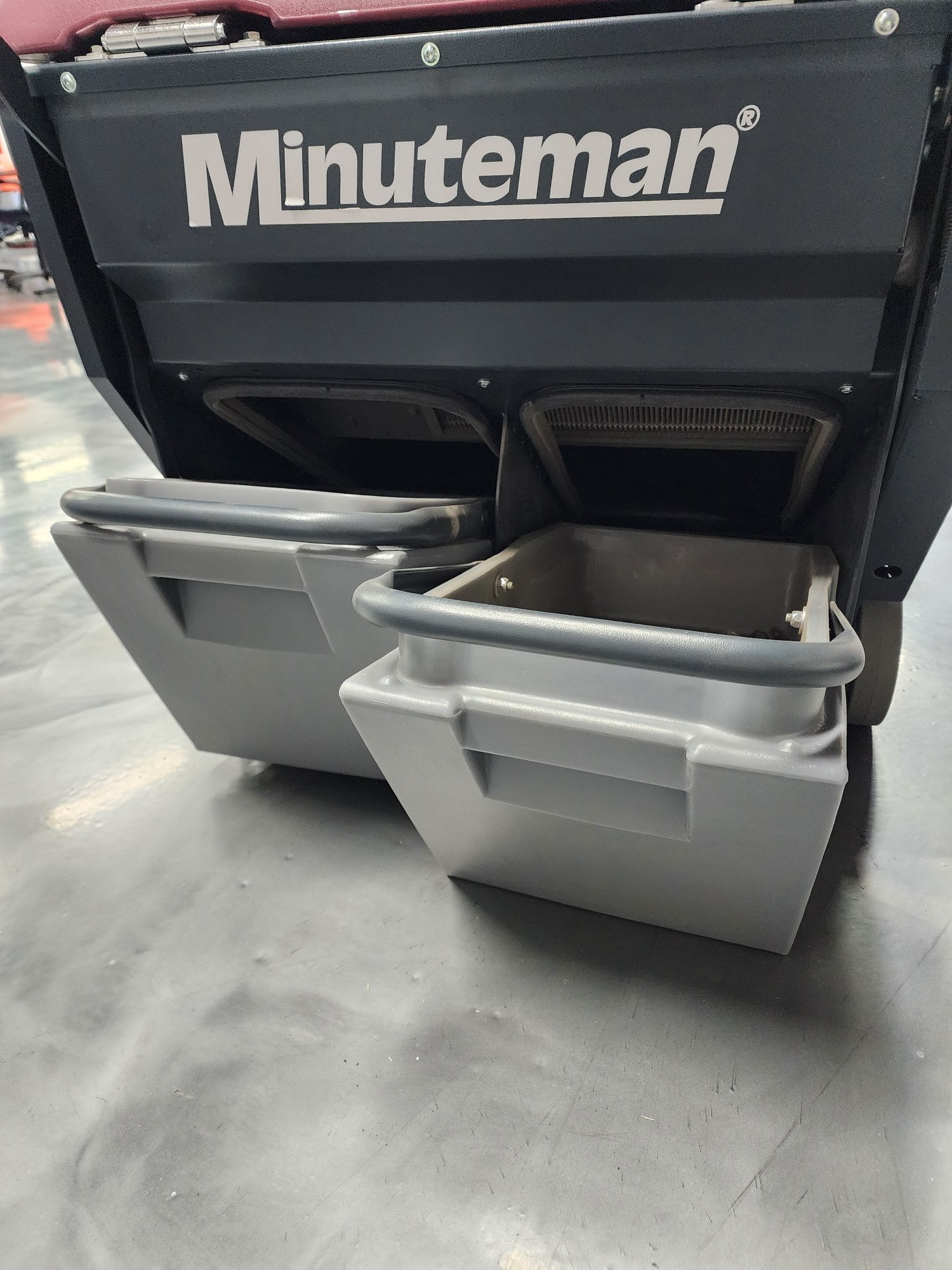 Minuteman Kleen Sweep 32R dual debris hoppers pulled out from the rear of the sweeper