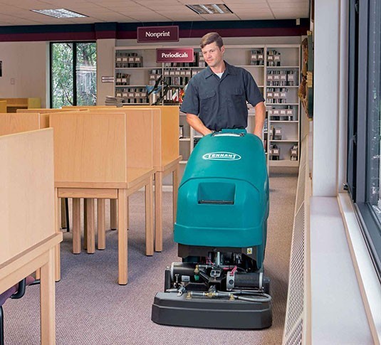 Operator cleaning library carpet with a Tennant 1610 carpet cleaner