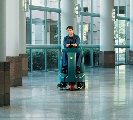 Nobles Speed Scrub Rider being driven across a polished convention center floor