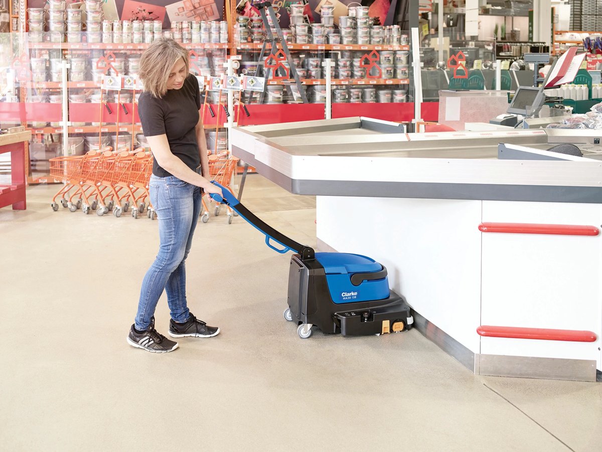 Clarke MA30 13B scrubbing a store floor along a checkout counter