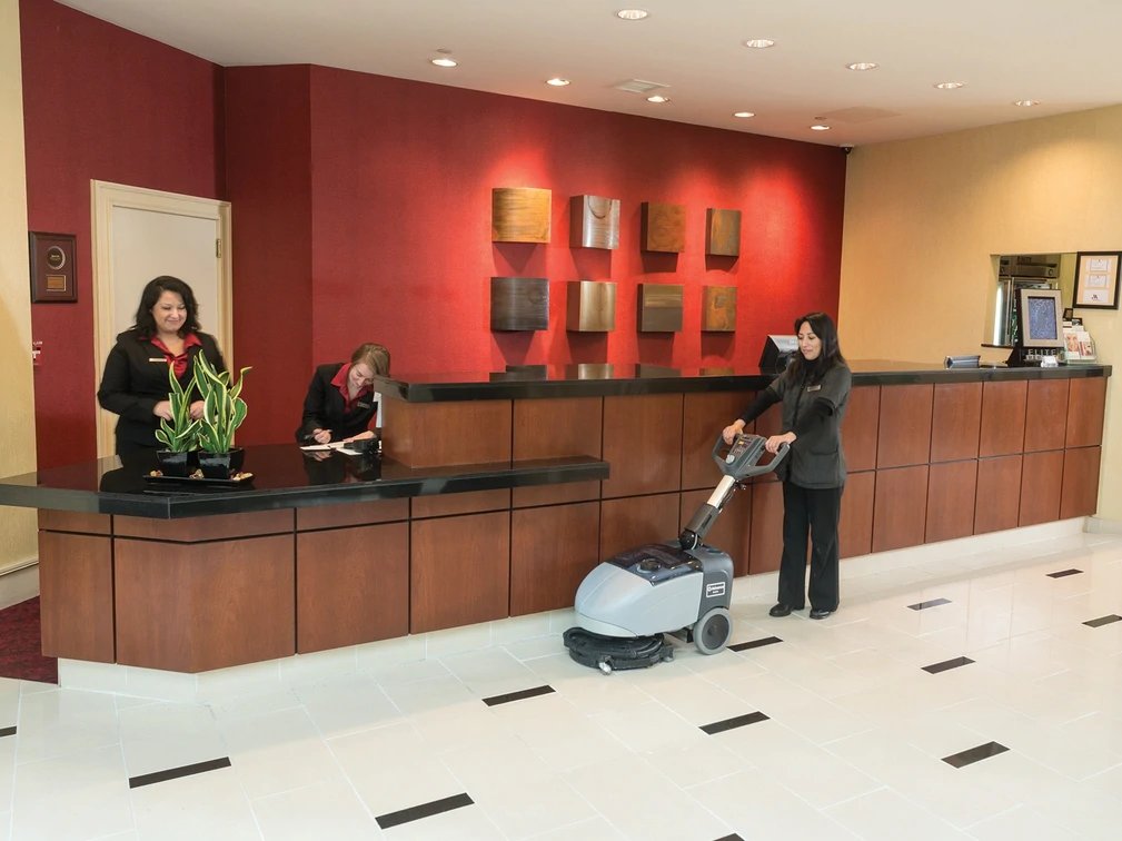 Advance SC351 micro scrubber cleaning a hotel lobby floor near the front desk