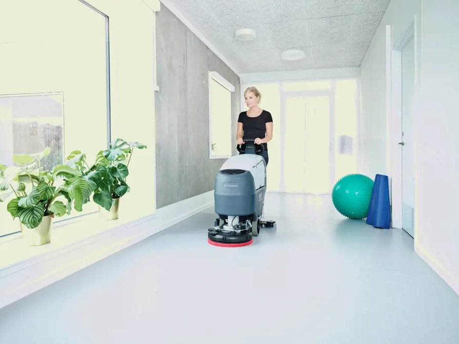 Operator using an Advance SC401 scrubber in a bright healthcare corridor