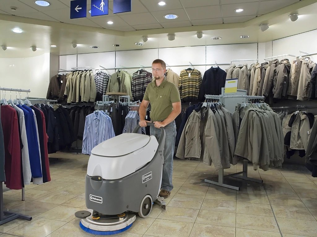 Operator using an Advance SC450 scrubber in a clothing store aisle