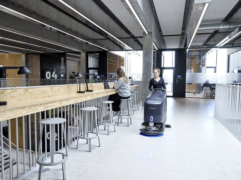 Nilfisk SC550 scrubber cleaning a school or office common area floor