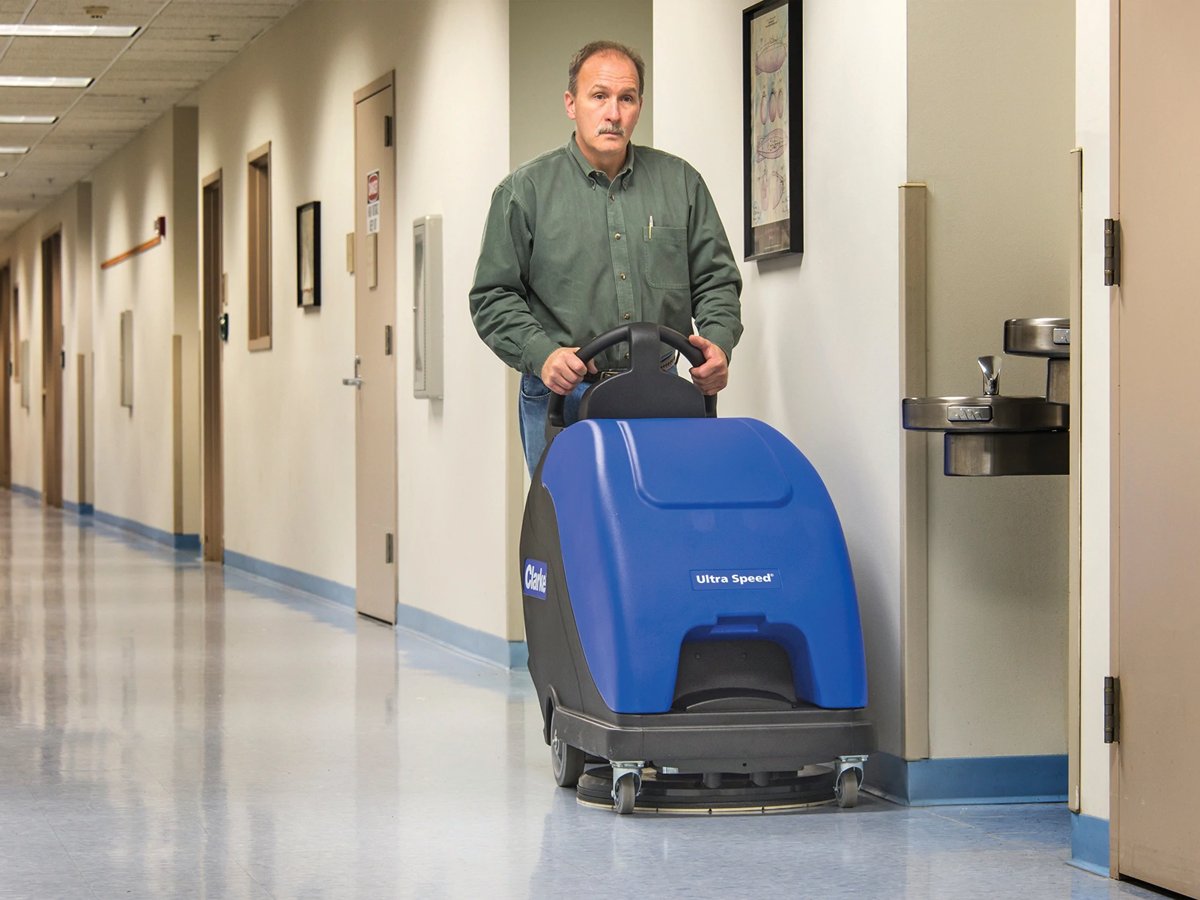 Operator burnishing a hallway floor with a Clarke Ultra Speed 20 battery burnisher