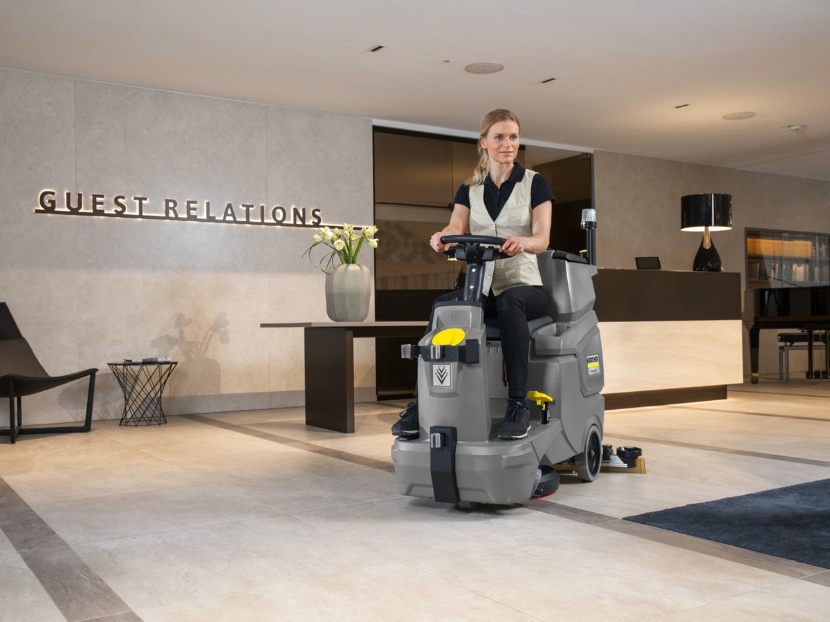 Operator riding a Kärcher BD 50/70 R Bp across a hotel lobby floor