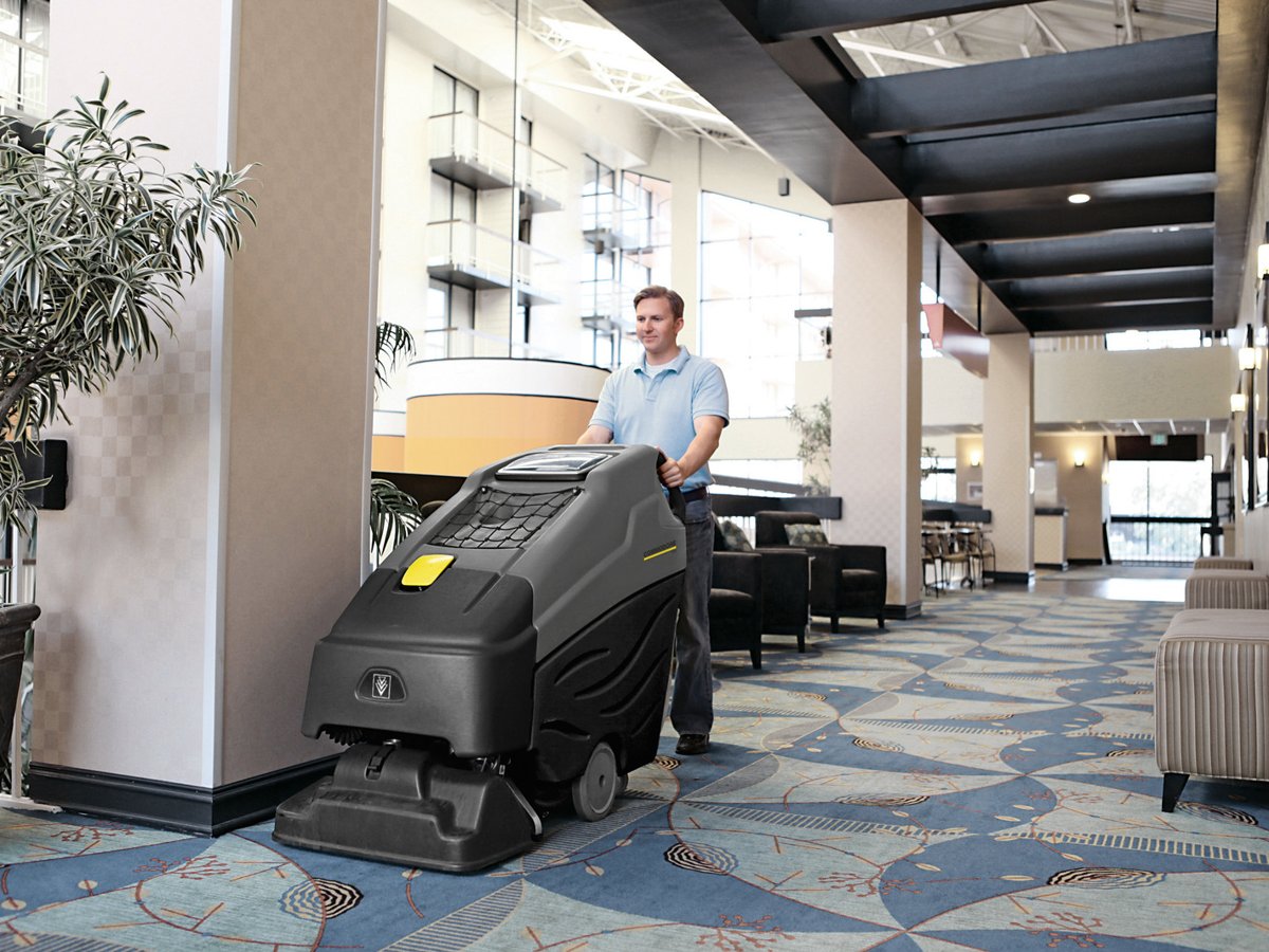 Operator cleaning lobby carpet with the Kärcher Commodore DUO