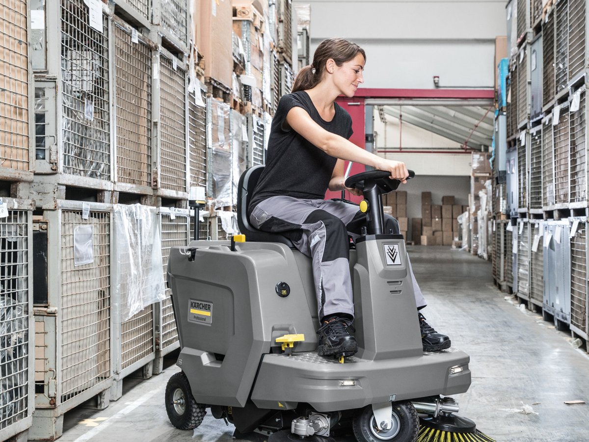 Operator sweeping a warehouse aisle with the Kärcher KM 85/50 R Bp