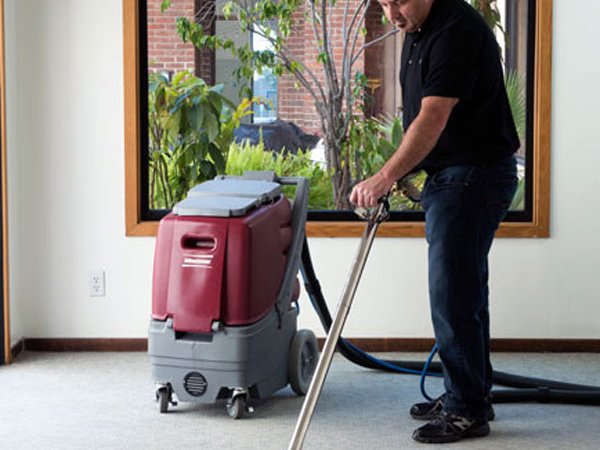Minuteman Rush portable extractor in use with a stainless carpet wand
