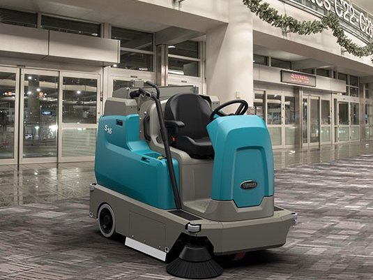 Tennant S16 ride-on sweeper working outside an airport terminal entrance