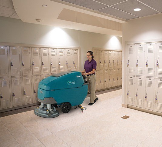 Tennant T600e disk scrubber cleaning a school locker room floor
